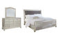 Coralayne Queen Upholstered Sleigh Bed with Mirrored Dresser